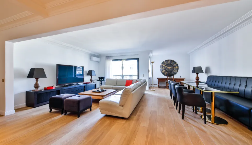 Salon et salle à manger modernes et lumineux avec parquet, mobilier design et TV grand écran. Idéal pour un appartement de luxe.