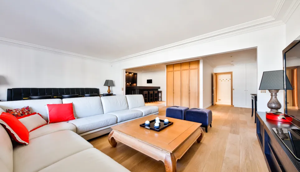 Salon de luxe spacieux et lumineux. Canapé design, parquet, ambiance moderne et élégante. Idéal pour un appartement de prestige.
