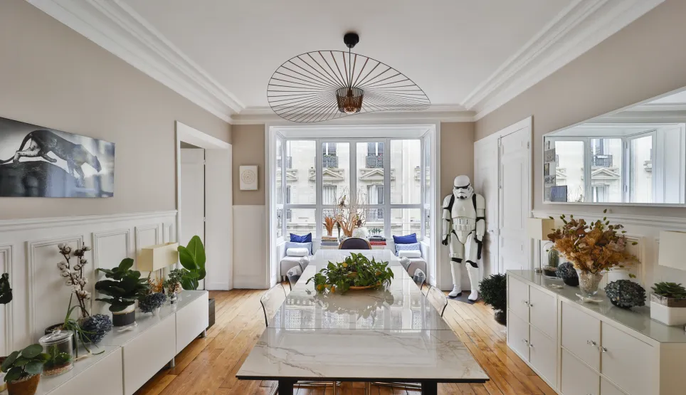 Salle à manger de luxe parisienne, design moderne et éclectique. Luminosité, parquet, moulures et vue ville. Un intérieur unique et raffiné.