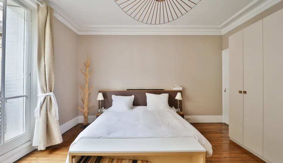 Chambre de luxe lumineuse avec parquet, design moderne et épuré. Idéale pour un appartement parisien élégant et confortable.