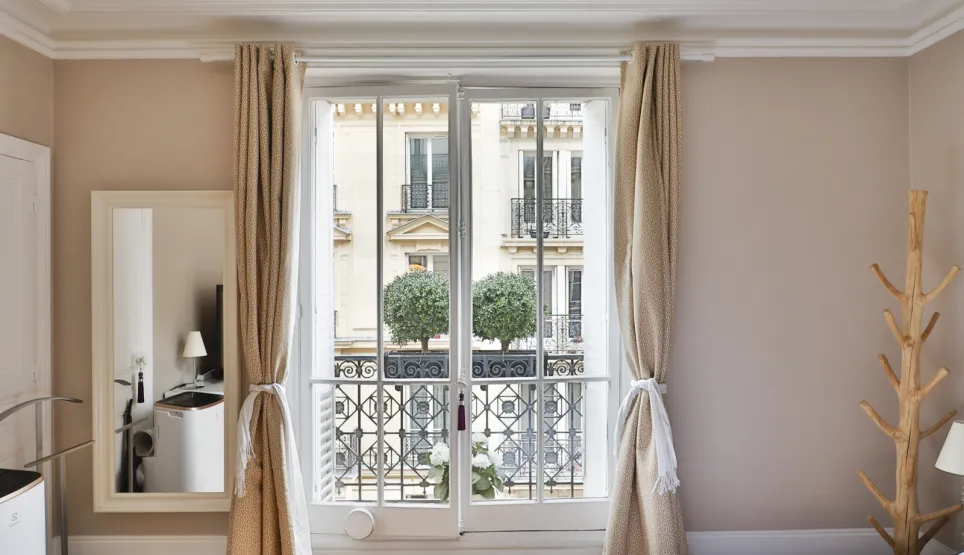 Chambre de luxe parisienne avec balcon, parquet, luminaire design. Élégance et vue urbaine pour un séjour raffiné.