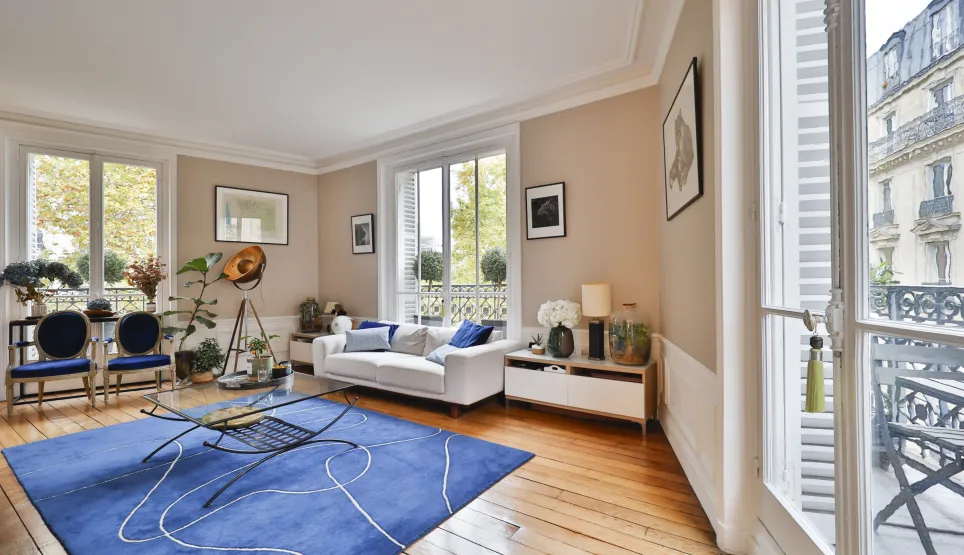 Salon de luxe lumineux, appartement parisien avec balcon. Design moderne, parquet, ambiance chic.