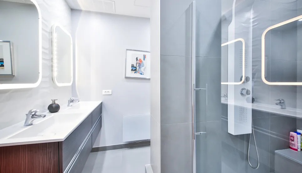Salle de bain luxe moderne avec double vasque, miroirs LED et douche vitrée. Design épuré, finitions haut de gamme pour propriété exclusive.