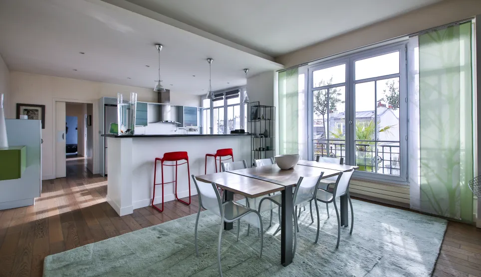 Appartement de luxe moderne avec cuisine ouverte, salle à manger lumineuse et vue. Design contemporain, parquet et grandes fenêtres.