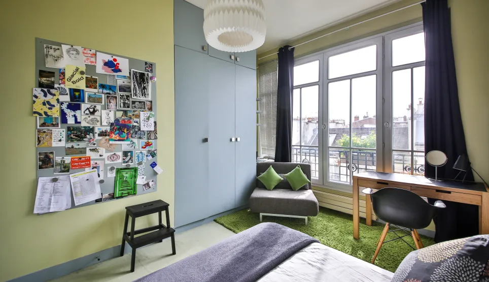 Chambre de luxe moderne, lumineuse, vue ville. Design contemporain, bureau, rangements intégrés. Idéal appartement urbain.