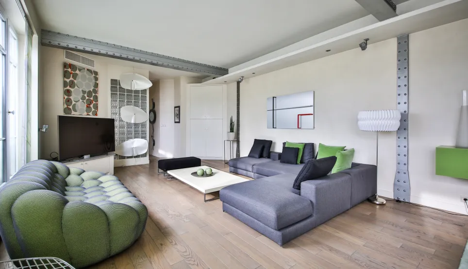Salon de luxe moderne et lumineux avec canapés design, parquet clair, poutres industrielles. Espace de vie contemporain et élégant.