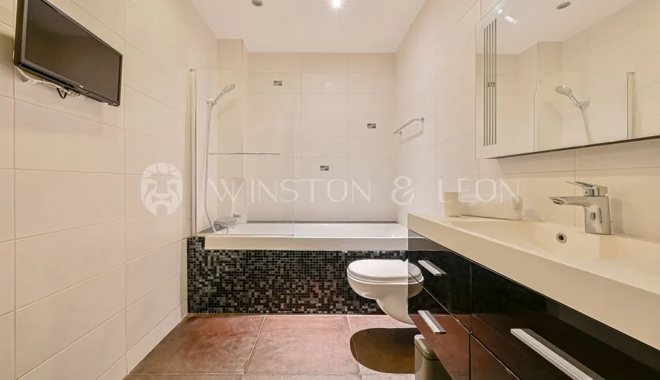 Salle de bain moderne avec baignoire, douche, WC et meuble vasque. Design épuré, finitions luxe.