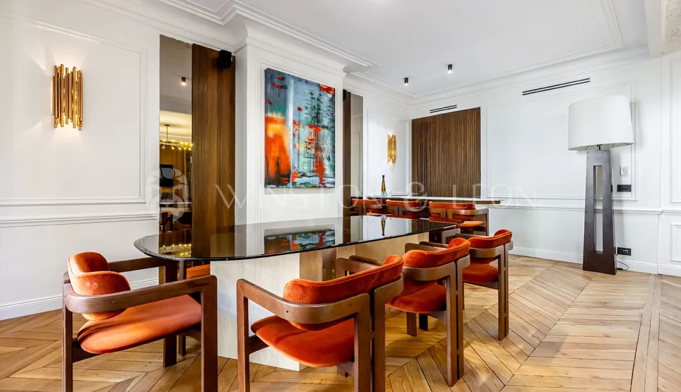Intérieur de luxe moderne: salle à manger élégante avec table en verre, chaises orange velours, art contemporain et parquet. Design raffiné.