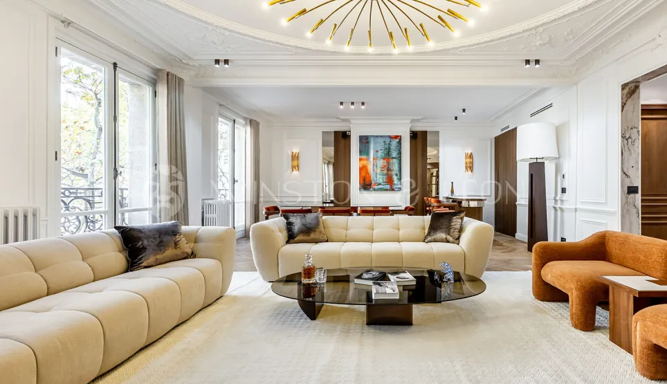 Salon de luxe contemporain avec mobilier design, plafonds hauts, grandes fenêtres et œuvres d'art. Élégance et confort pour un intérieur d'exception.