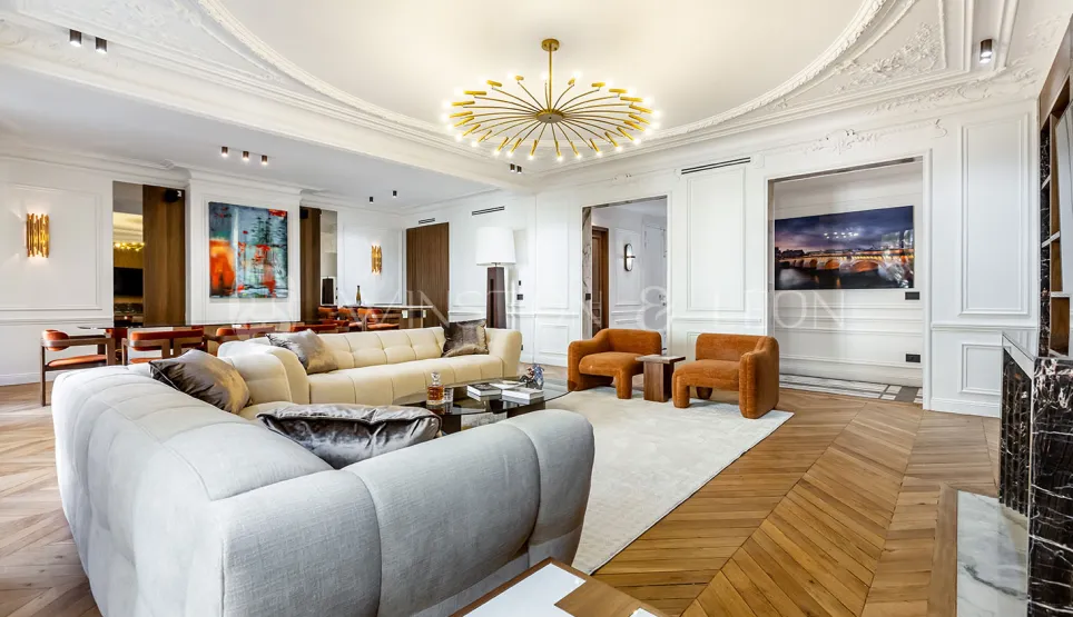 Sublime salon d'appartement de luxe parisien. Ambiance haussmannienne modernisée, mobilier design, parquet, moulures, lustre contemporain.