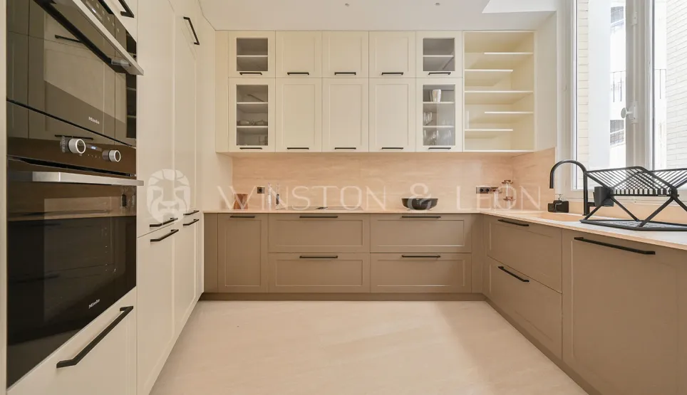 Cuisine de luxe moderne bicolore (crème/taupe), électroménager Miele intégré. Design élégant et fonctionnel pour un intérieur haut de gamme.