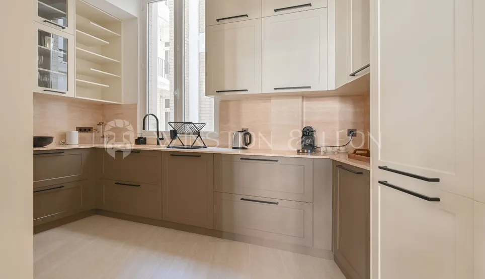 Cuisine de luxe moderne bicolore (beige/taupe), design épuré, finitions haut de gamme. Idéale pour un appartement contemporain.