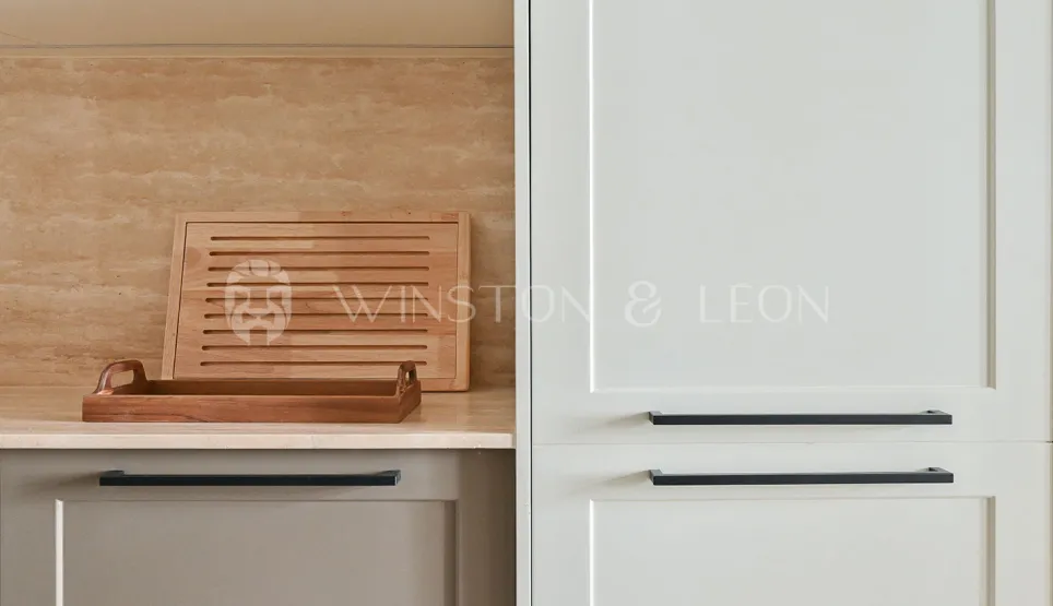 Cuisine de luxe moderne: armoires claires, poignées noires, crédence travertin, accents bois. Design élégant et fonctionnel.