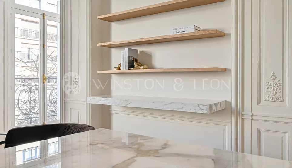 Sublime design intérieur luxe: table marbre, étagères bois, boiseries élégantes, fenêtre haussmannienne. Raffinement et luminosité pour propriété d'exception.