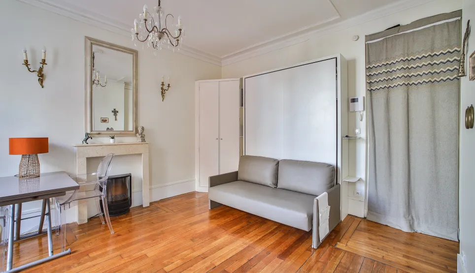 Studio parisien élégant et lumineux. Parquet, cheminée, lit escamotable design. Optimisation d'espace luxe. Idéal investissement.