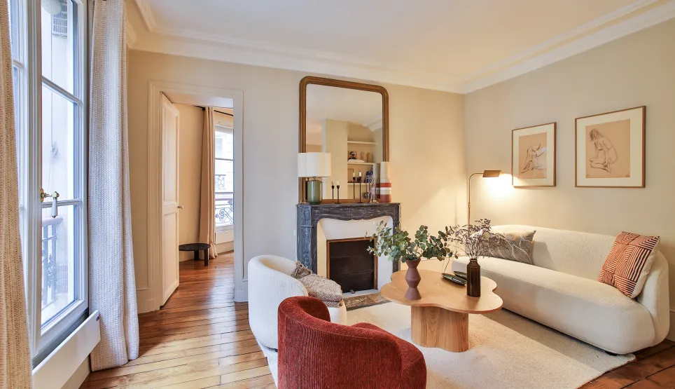 Salon parisien luxe, design moderne et élégant avec cheminée, parquet et lumière naturelle. Idéal pour un appartement haut de gamme.