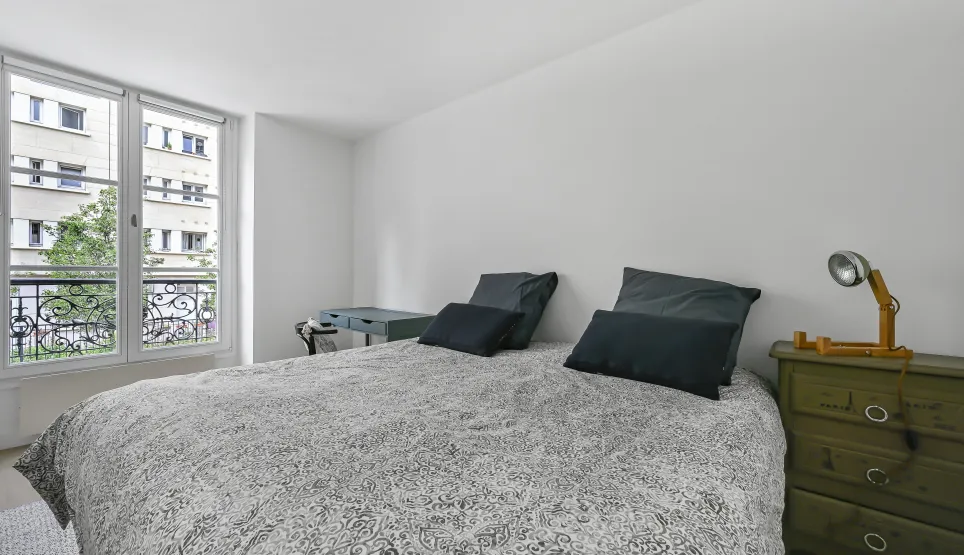 Suite parentale lumineuse, design épuré, vue urbaine, balcon fer forgé. Confort et élégance pour votre appartement de luxe.