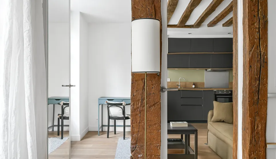 Intérieur de luxe rénové: poutres apparentes, cuisine moderne, design élégant. Charme ancien et confort contemporain.