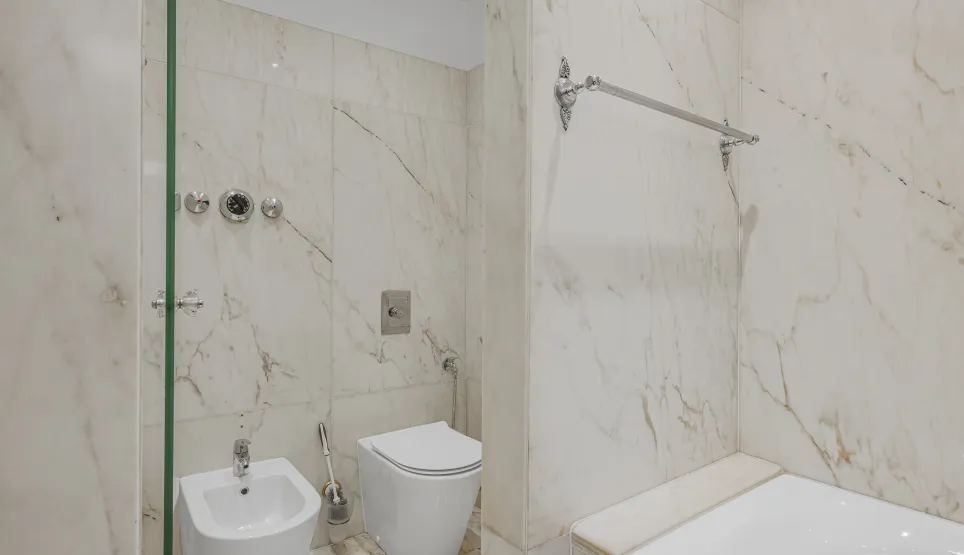 Salle de bain de luxe en marbre avec douche, baignoire, WC et bidet. Design élégant et finitions haut de gamme.