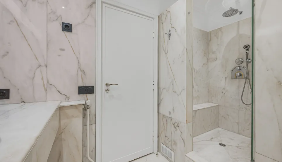 Salle de bain de luxe en marbre, douche italienne moderne et élégante. Design contemporain pour un bien immobilier haut de gamme.