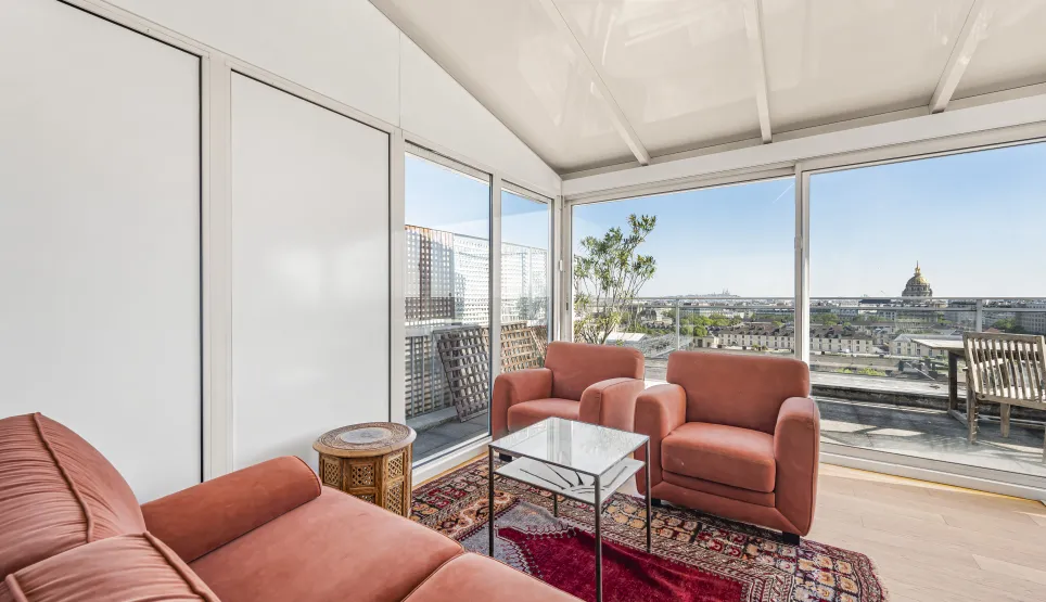 Penthouse de luxe à Paris avec vue panoramique sur les Invalides et terrasse ensoleillée. Salon élégant et lumineux.