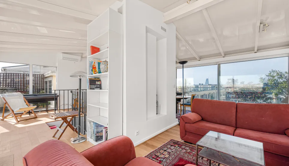 Penthouse de luxe : salon moderne et lumineux avec vue panoramique sur la ville, grandes baies vitrées et accès terrasse. Design contemporain.