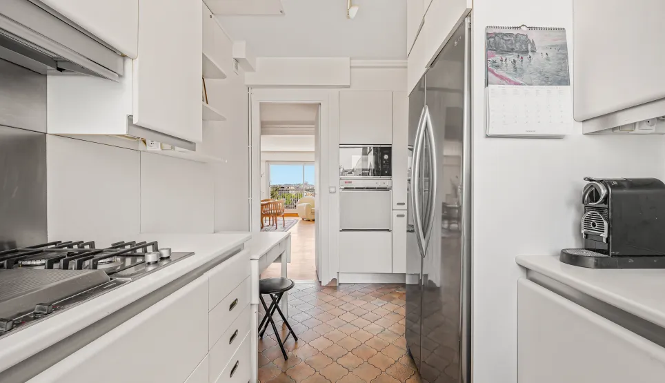 Cuisine moderne lumineuse, équipements intégrés, carrelage unique. Vue dégagée depuis le salon. Idéal appartement de luxe, confort et style.