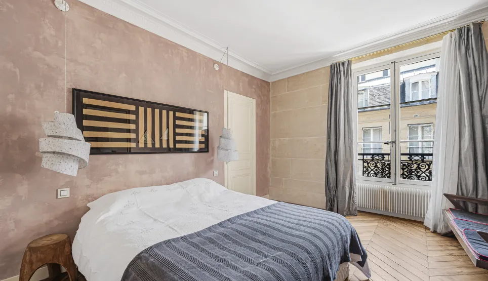 Chambre parisienne de luxe. Design moderne, murs texturés, parquet, vue ville. Ambiance élégante et raffinée.