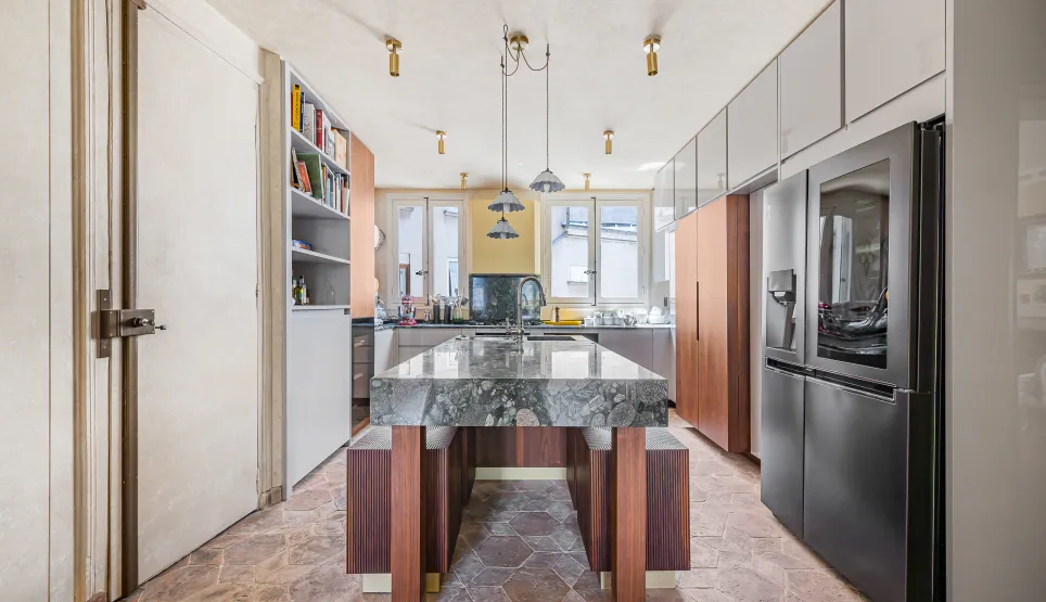 Cuisine de luxe moderne avec îlot central en marbre, électroménager haut de gamme et design élégant. Idéale pour un appartement parisien.