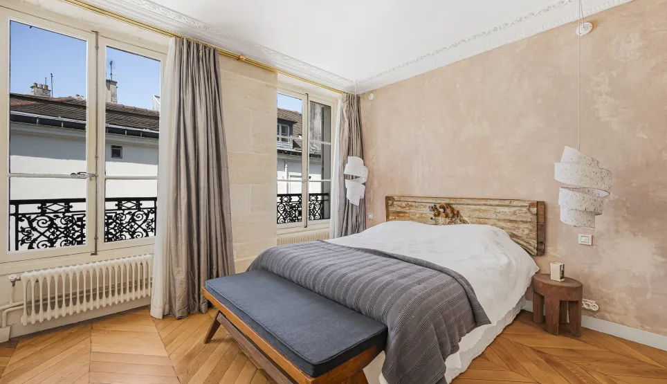 Chambre de luxe parisienne. Parquet, vue sur la ville, design élégant et confortable. Ambiance raffinée.