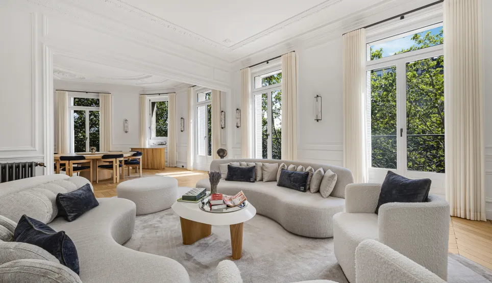Salon de luxe lumineux et élégant, design moderne, mobilier contemporain, grandes fenêtres, moulures. Idéal appartement haussmannien.