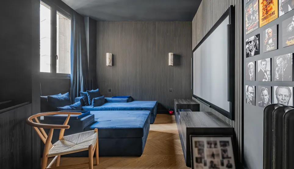 Home cinéma de luxe: banquettes velours bleu, grand écran, murs design. Expérience immersive pour divertissement haut de gamme.