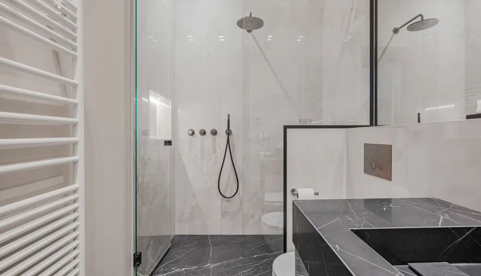 Salle de bain de luxe moderne: douche à l'italienne marbre noir & blanc, vasque design, sèche-serviettes. Élégance et confort.