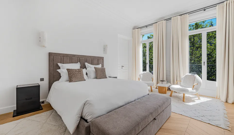 Chambre de maître luxueuse, design épuré, vue verdoyante. Confort et élégance pour un immobilier de prestige. Appartement haut standing.
