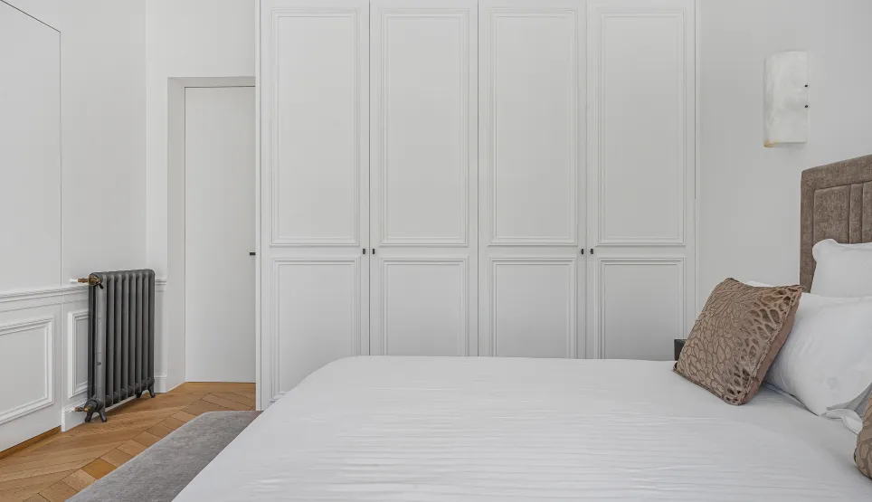 Chambre luxe épurée. Placards intégrés, lit confortable, parquet. Design contemporain, élégance et sérénité pour une suite parentale.