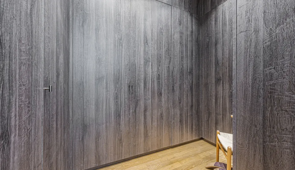 Design luxe: boiseries sombres intégrées, parquet clair. Intérieur moderne et épuré, idéal pour un couloir ou dressing haut de gamme.