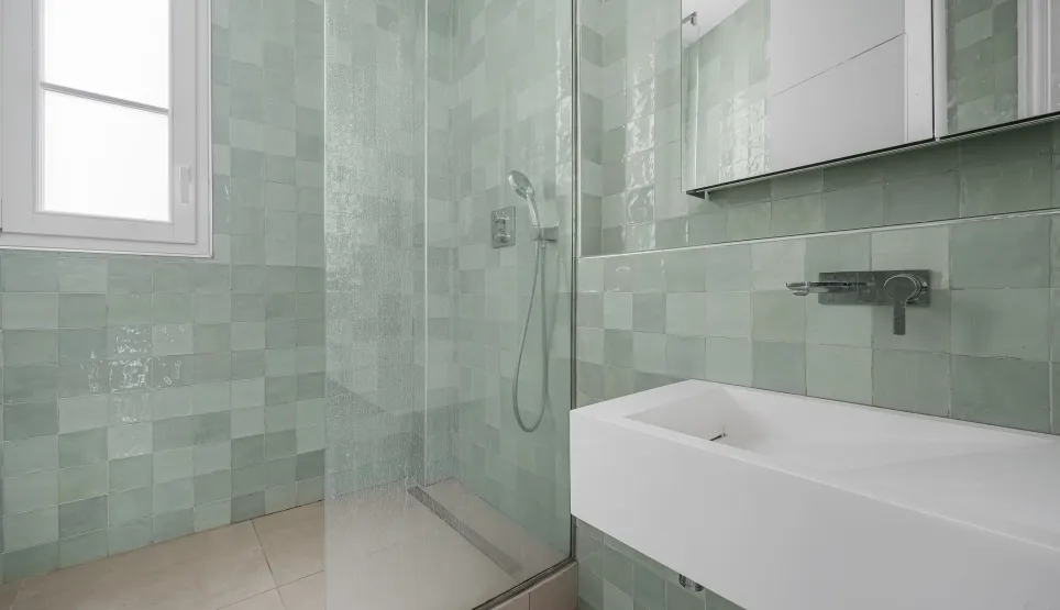 Salle de bain de luxe moderne. Douche à l'italienne, carrelage zellige vert d'eau, lavabo design. Élégance et raffinement pour un intérieur haut de gamme.