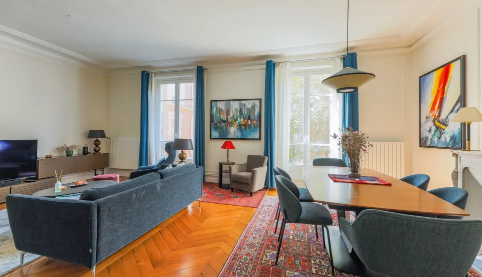 Appartement de luxe spacieux et lumineux. Salon-salle à manger élégant avec parquet, grandes fenêtres et design contemporain. Idéal pour un style de vie parisien chic.