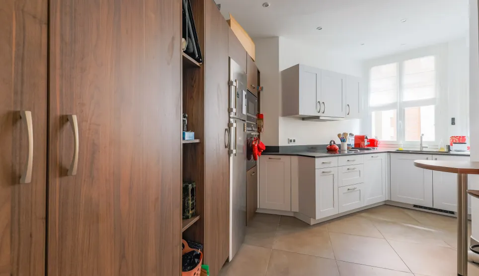 Cuisine moderne et lumineuse avec boiseries élégantes, électroménager inox intégré et finitions haut de gamme. Idéal pour propriété de luxe.