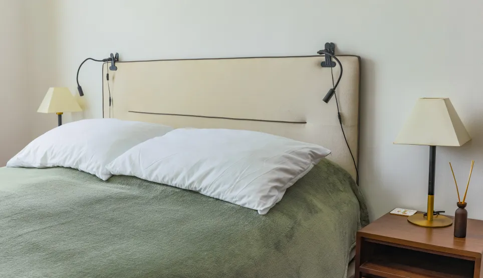 Chambre de luxe moderne. Lit douillet, tête de lit design, éclairage intégré, table de chevet élégante. Espace serein pour un repos optimal.