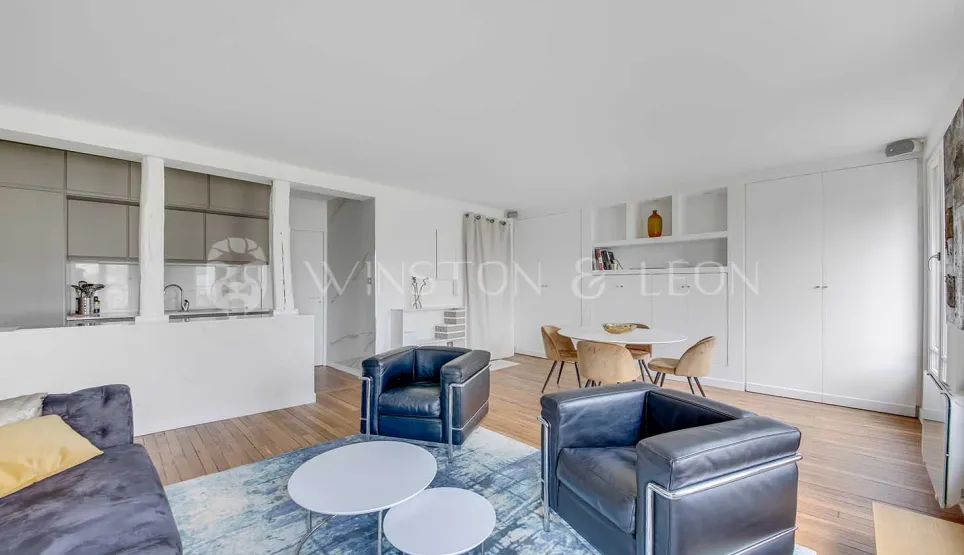 Salon-salle à manger ouvert et lumineux avec cuisine moderne intégrée. Mobilier design, ambiance contemporaine et raffinée pour un appartement de luxe.