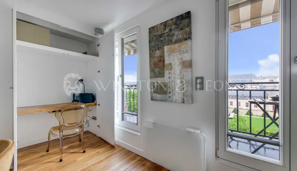 Coin bureau lumineux avec vue sur balcon, parquet. Design moderne pour un espace de travail élégant dans un appartement de luxe. Idéal télétravail.