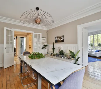 Salle à manger de luxe, table marbre, lustre design, parquet. Espace de vie lumineux, élégant et spacieux pour appartement de prestige.