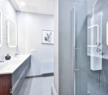 Salle de bain luxe moderne avec double vasque, miroirs LED et douche vitrée. Design épuré, finitions haut de gamme pour propriété exclusive.