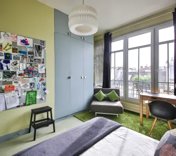Chambre de luxe moderne, lumineuse, vue ville. Design contemporain, bureau, rangements intégrés. Idéal appartement urbain.