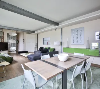 Superbe loft de luxe, design contemporain. Salon-salle à manger lumineux, mobilier élégant, poutres industrielles. Espace de vie moderne et spacieux.