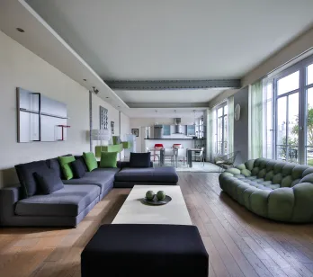 Salon moderne luxe avec canapés design, parquet, cuisine ouverte. Appartement spacieux et lumineux pour vie contemporaine.