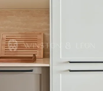 Cuisine de luxe moderne: armoires claires, poignées noires, crédence travertin, accents bois. Design élégant et fonctionnel.