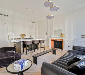 Salon de luxe parisien, fusion design contemporain & classique. Appartement élégant avec bar, cheminée, moulures, parquet et mobilier haut de gamme.