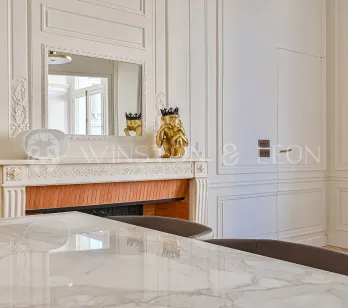 Élégant intérieur Haussmannien: boiseries, cheminée ornée, miroir, table marbre. Luxe parisien raffiné, design chic.